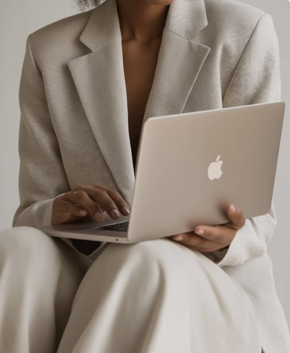 MacBook on the lap in a calm, light-filled studio