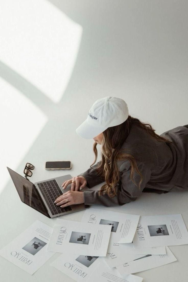 Laptop with printed editorial layouts on the floor