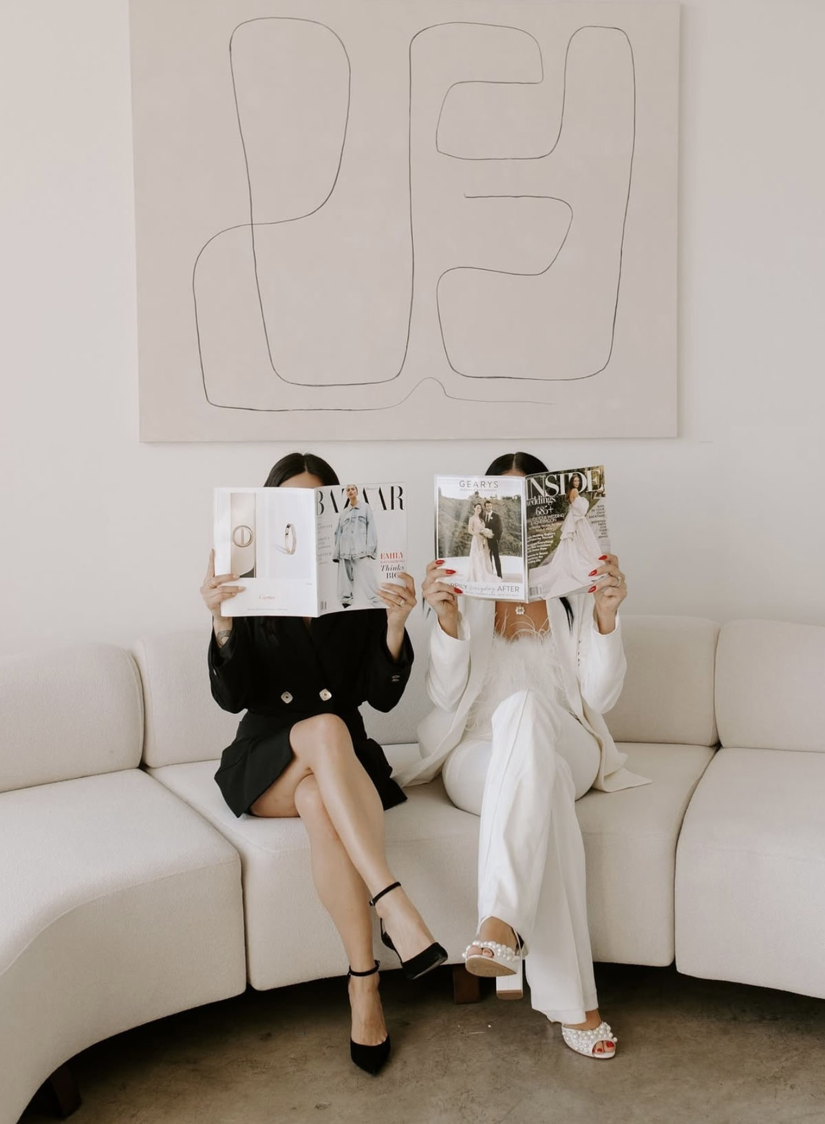 Stack of editorial magazines with a hand of its own on the sofa